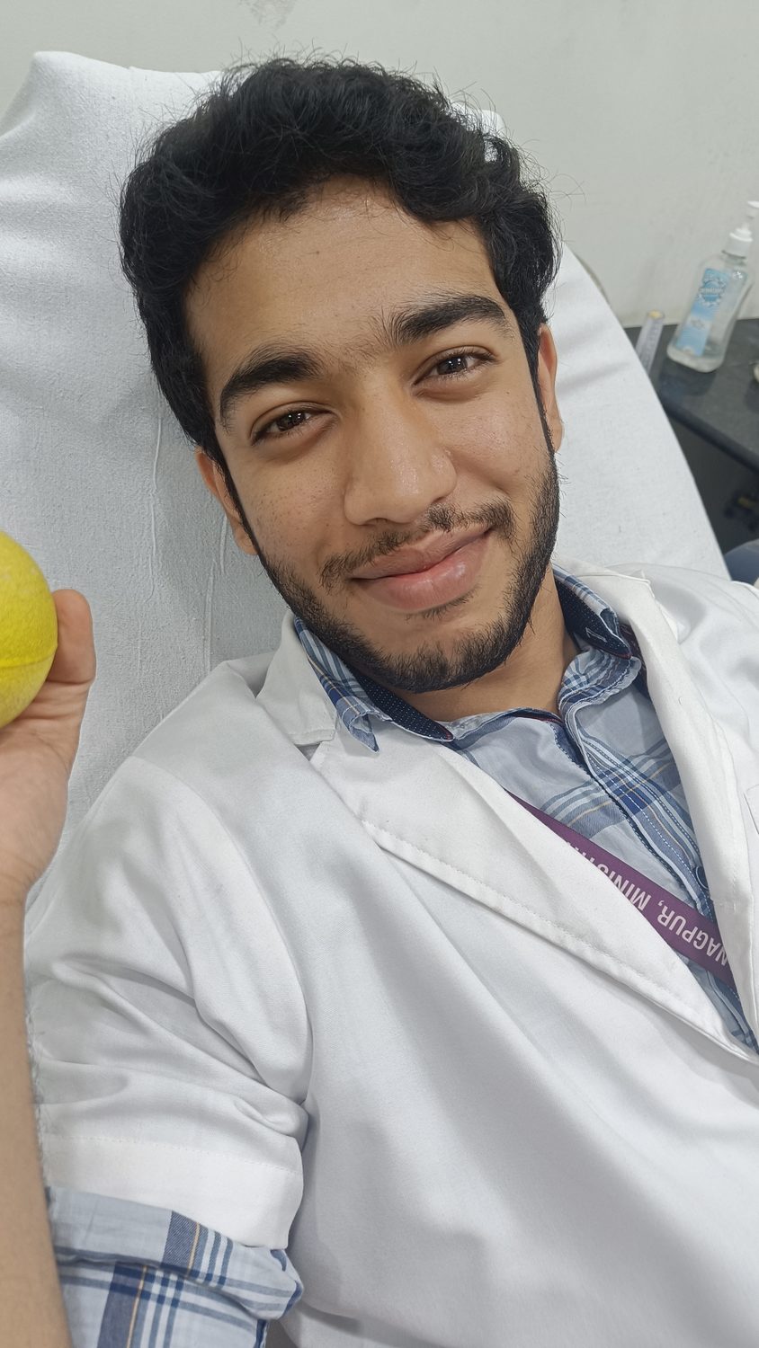 Sumit in a white coat at a rural health camp.