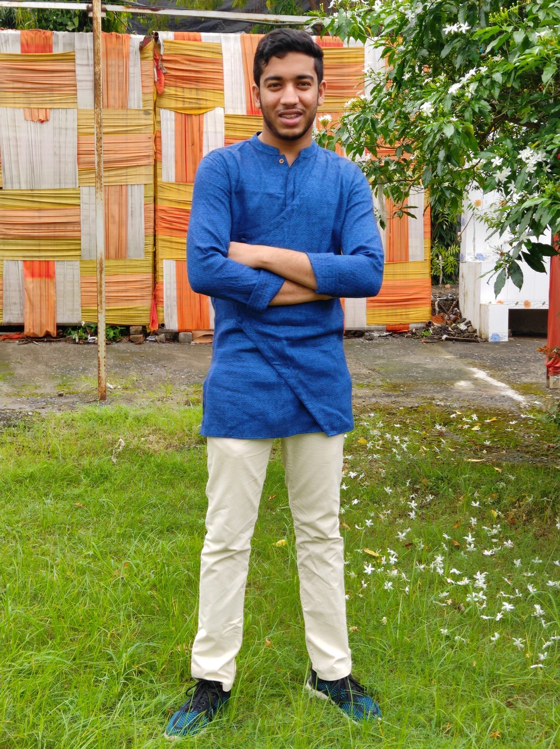 Sumit in a blue kurta, arms crossed.