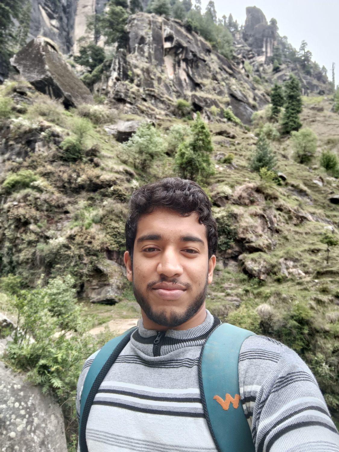 Sumit on a mountain trail with a backpack.